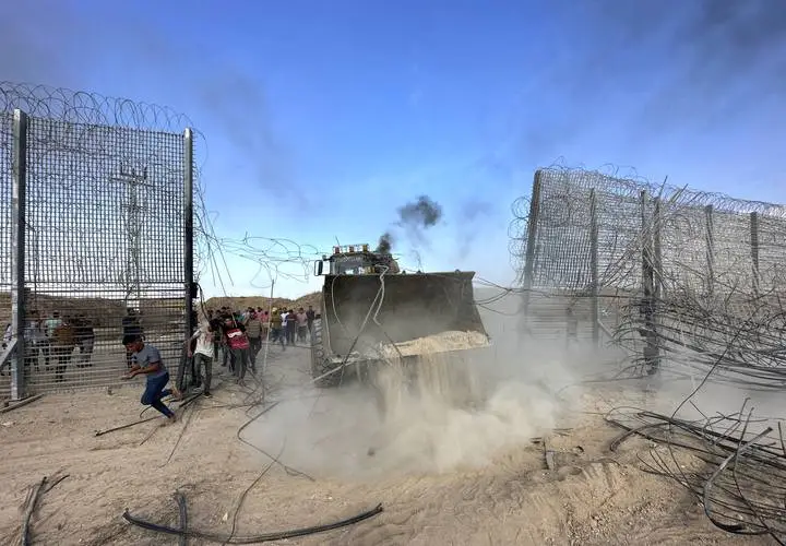 Palestinos rompem cerca da fronteira nominal em Gaza, em 7 de outubro de 2023 [Ashraf Amra/Agência Anadolu]

