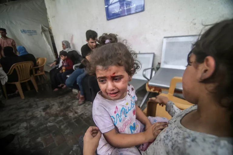 Uma criança ferida espera do lado de fora de um hospital enquanto os ataques aéreos israelenses continuam no sexto dia em Rafah, Gaza, em 12 de outubro de 2023. [Abed Rahim Khatib/Anadolu]