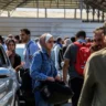Cidadãos binacionais de Gaza esperam na travessia de Rafah para entrar no Egito, após oito dias de intensos bombardeios israelenses ao território sitiado, 14 de outubro de 2023 [Abed Rahim Khatib/Agência Anadolu]