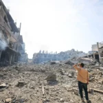 Um homem observa a destruição em um bairro devastado no campo de refugiados de Jabalia, na Faixa de Gaza, em 11 de outubro de 2023 [Mahmud Hams/AFP via Getty Images]