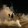 Manifestantes sob nuvens de gás lacrimogêneo enquanto a polícia tenta dispersar uma manifestação não autorizada em apoio aos palestinos na Place de la Republique, em Paris, em 12 de outubro de 2023. [DIMITAR DILKOFF/AFP via Getty Images]