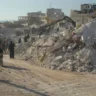 Moradores passam pelos escombros de edifícios desabados em Harém, na Síria, após o terremoto de fevereiro de 2023 [ PMA ]