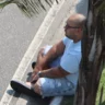 Taillon sentado no meio-fio durante abordagem da PF na Barra da Tijuca — Foto: Reprodução