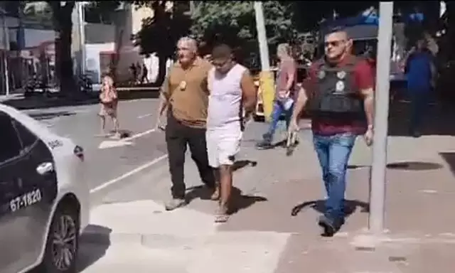 Reinaldo Carvalho de Oliveira, conhecido como Rei, deixando apartamento escoltado por policiais nesta quarta-feira (Foto: Reprodução de vídeo divulgada pelo O Globo)