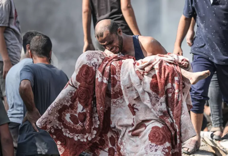 Palestina carrega o corpo de um menino nos braços, morto por bombardeios israelenses ao campo de refugiados de Bureij, no centro de Gaza, em 2 de novembro de 2023 [Mustafa Hassona/Agência Anadolu]