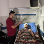 Nas últimas 24 horas, os hospitais em Gaza têm estado sob bombardeios implacáveis. O complexo hospitalar de Al Shifa, a maior unidade de saúde onde a equipe de MSF ainda trabalha, foi atingido diversas vezes, inclusive nos departamentos de maternidade e ambulatório, resultando em múltiplas mortes e feridos. As hostilidades em torno do hospital não pararam. Equipes de MSF e centenas de pacientes ainda estão dentro do hospital Al Shifa. MSF reitera urgentemente o seu apelo ao fim dos ataques contra hospitais, a um cessar-fogo imediato e à proteção das instalações médicas, do pessoal médico e dos pacientes. “Estamos sendo mortos aqui, por favor, faça alguma coisa”, escreveu esta manhã um enfermeiro de MSF do porão do hospital Al Shifa, onde ele e sua família estavam se abrigando dos incessantes bombardeios. “Quatro ou cinco famílias estão abrigadas agora no porão; o bombardeio está tão perto que meus filhos estão chorando e gritando de medo. ” “A situação em Al Shifa é verdadeiramente catastrófica. Apelamos ao governo israelense para que cesse este ataque implacável ao sistema de saúde de Gaza. Nossa equipe e pacientes estão dentro do hospital Al Shifa, onde os bombardeios pesados não pararam desde ontem”, diz Ann Taylor, coordenadora-geral de MSF nos Territórios Palestinos. O hospital Al Shifa é o principal complexo hospitalar da Faixa de Gaza, com 700 leitos, que presta atendimento emergencial e cirúrgico. Atualmente, não há outras instalações na Faixa capazes de admitir e tratar tantos pacientes com lesões complexas, por vezes fatais. Apesar dos ataques regulares e da escassez, a equipe conseguiu manter o hospital operacional. Ontem (10/11), o hospital Al Shifa ficou sem energia elétrica. As ambulâncias não podem mais se mover para recolher os feridos, e o bombardeio ininterrupto impede a evacuação de pacientes e profissionais. No momento em que este artigo foi escrito, nossa equipe estava testemunhando pessoas sendo baleadas enquanto tentavam fugir do hospital. “Há muitos pacientes já operados e que não conseguem andar. Eles não podem ser evacuados”, disse o Dr. Mohammed Obeid, cirurgião de MSF no hospital Al Shifa. “Precisamos de uma ambulância para transportá-los, não temos ambulâncias para evacuar todos esses pacientes”. "Não podemos sair porque de ontem de manhã até agora operamos cerca de 25 pacientes. Se eu não estiver aqui ou o outro cirurgião, quem cuidará dos pacientes?”, questiona Obeid. “Há um paciente que precisa de cirurgia, outro que já está dormindo [sob anestesia].” MSF denuncia a sentença de morte de civis atualmente presos no hospital Al Shifa, assinada pelos militares israelenses. É necessário que haja um cessar-fogo urgente e incondicional por todas as partes em conflito; a ajuda humanitária tem de ser fornecida agora a toda a Faixa de Gaza. MSF perdeu contato com um cirurgião que trabalha e se abriga no hospital Al-Quds com sua família. Outras instalações de saúde, incluindo o hospital Al Rantisi, que MSF também apoiou no passado, teriam sido cercadas por tanques israelenses. Instamos os EUA, o Reino Unido, o Canadá, os Estados-membros da Liga dos Estados Árabes, os Estados-membros da Organização de Cooperação Islâmica e a União Europeia, que repetidamente apelaram ao respeito do Direito Internacional Humanitário (DIH), a tomarem medidas para garantir um cessar-fogo agora. Os horrores que se desenrolam diante dos nossos olhos em Gaza mostram claramente que os apelos à contenção e à adesão ao DIH foram ignorados. Trabalhar com o objetivo de alcançar um cessar-fogo é a forma mais eficaz de garantir a proteção dos civis. Milhares de pessoas ficaram feridas desde 7 de outubro, muitas das quais estão em estado crítico e necessitarão de cirurgias complexas e tratamento prolongado durante semanas, senão meses. Isto só pode ser feito com um cessar-fogo total e o fornecimento incondicional de ajuda humanitária, incluindo o acesso a alimentos, combustível e água; a sobrevivência das pessoas em Gaza depende diss