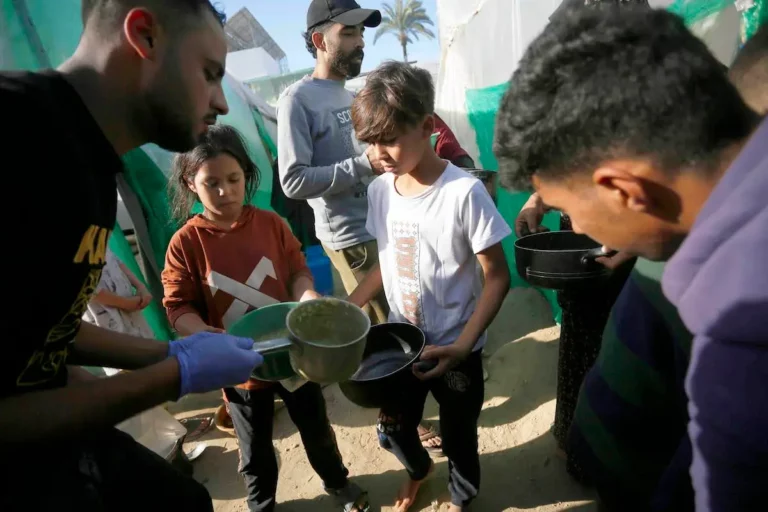 Palestinos deslocados distribuem recursos escassos em um campo improvisado em Deir al-Balah, na Faixa de Gaza sitiada, em 16 de dezembro de 2023 [Ashraf Amra/Agência Anadolu]