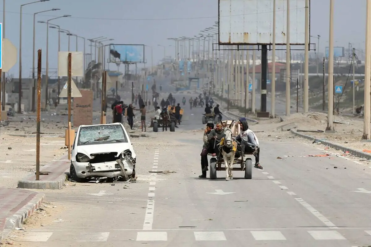 Os palestinos que vivem na área migram para o sul depois que as forças israelenses invadiram o Hospital Shifa e forçaram os residentes do hospital e da área circundante a migrar, passando por um rio chamado Vale de Gaza em Deir Al Balah, Gaza, em 18 de março de 2024. [Ashraf Amra – Agência Anadolu]