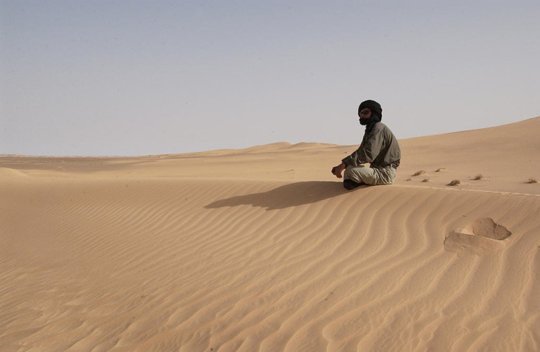 Um homem sentado nos arredores do campo de refugiados Awsaard, em Dakhla, no Saara Ocidental, na Argélia. (Foto: Evan Schneider / UN Photo)