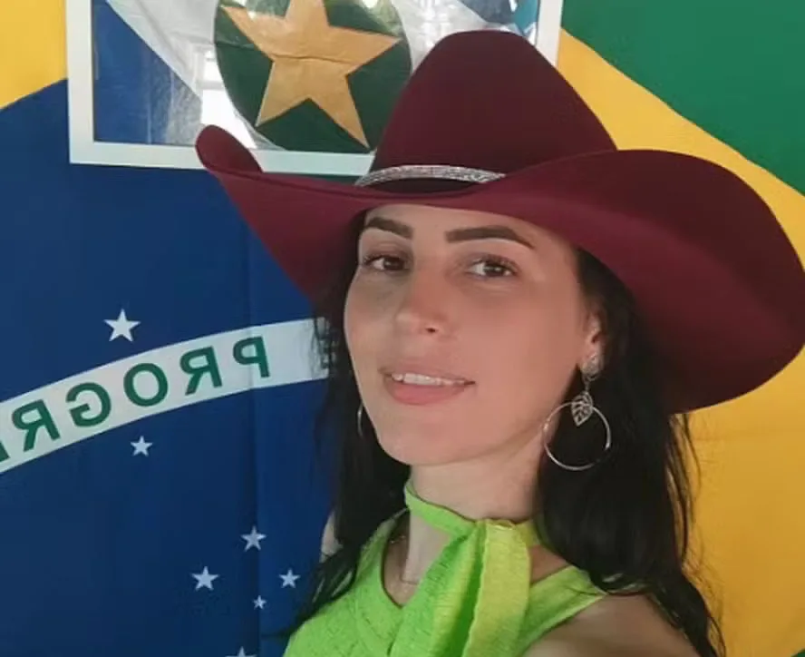 Raquel Catani posa para foto em frente à bandeira do Brasil e de Matogrosso