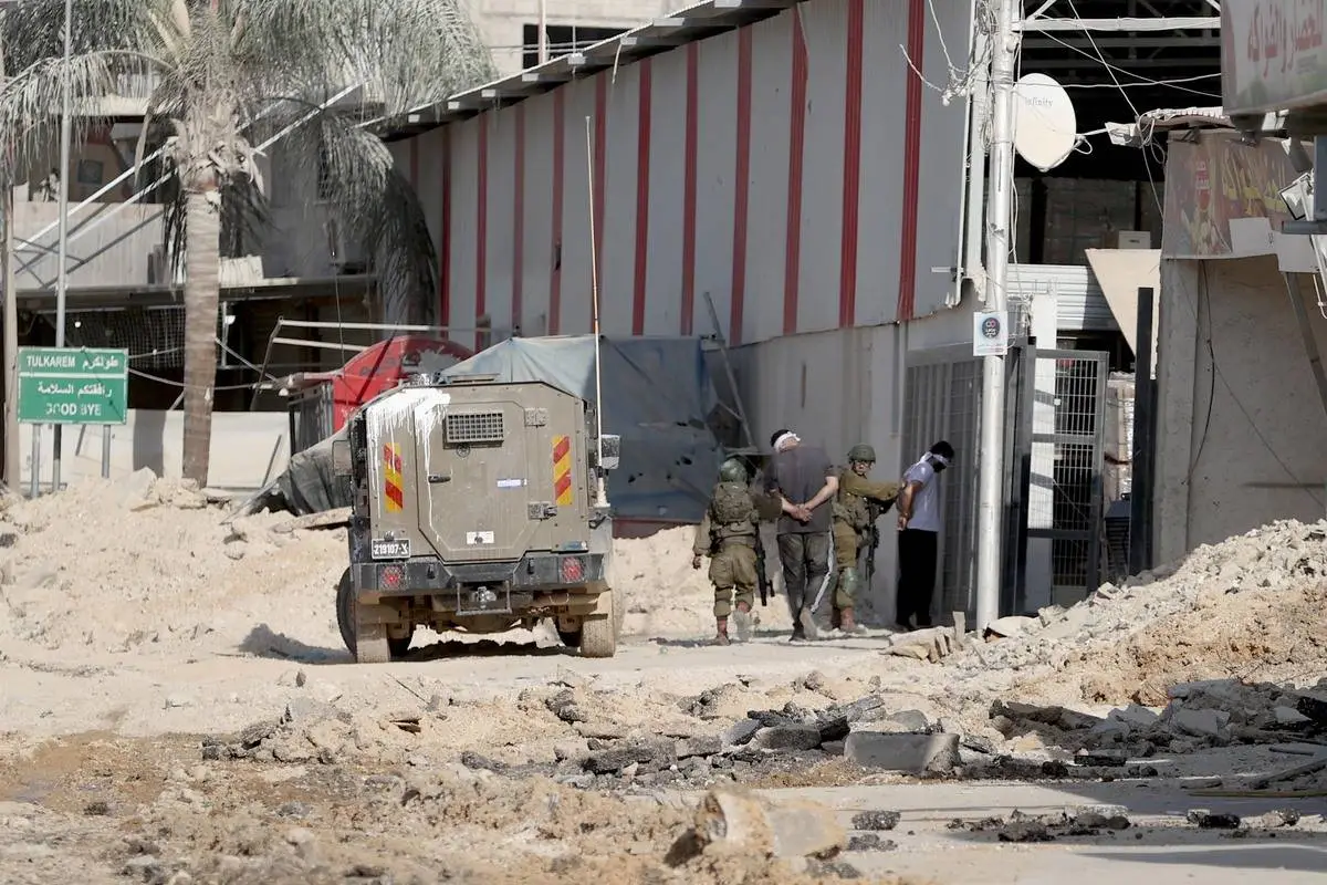 Soldados israelenses prendem cidadãos palestinos durante invasão ao campo de refugiados de Nour Shams, na região de Tulkarem, na Cisjordânia ocupada, em 28 de agosto de 2024 [Issam Rimawi/Agência Anadolu]