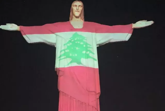 Estátua do Cristo Redentor iluminada com a bandeira do Líbano, em homenagem às vítimas da explosão no porto de Beirute, no Rio de Janeiro, em 6 de agosto de 2020 [ Santuário Cristo Redentor]