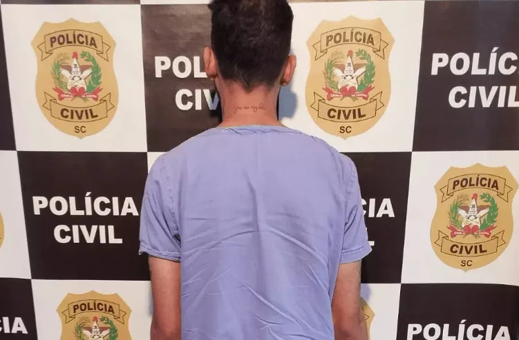 Homem posa para foto na delegacia.