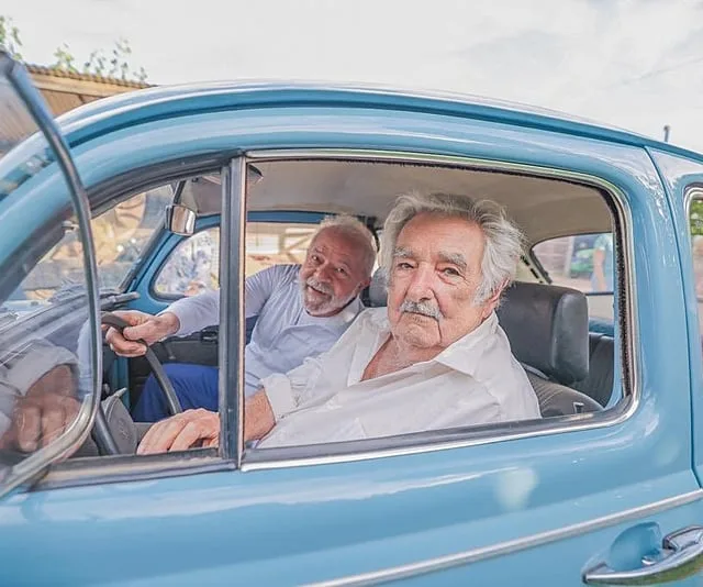 Pepe Mujica andando em seu fusca ao lado do presidente Lula - Foto: Ricardo Stuckert