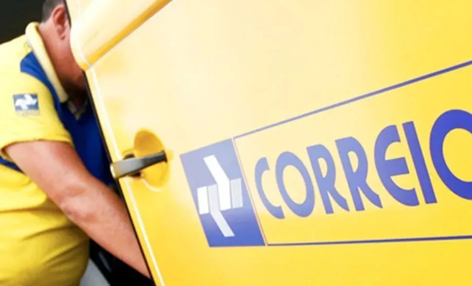 Funcionário retira encomendas de carro dos Correios