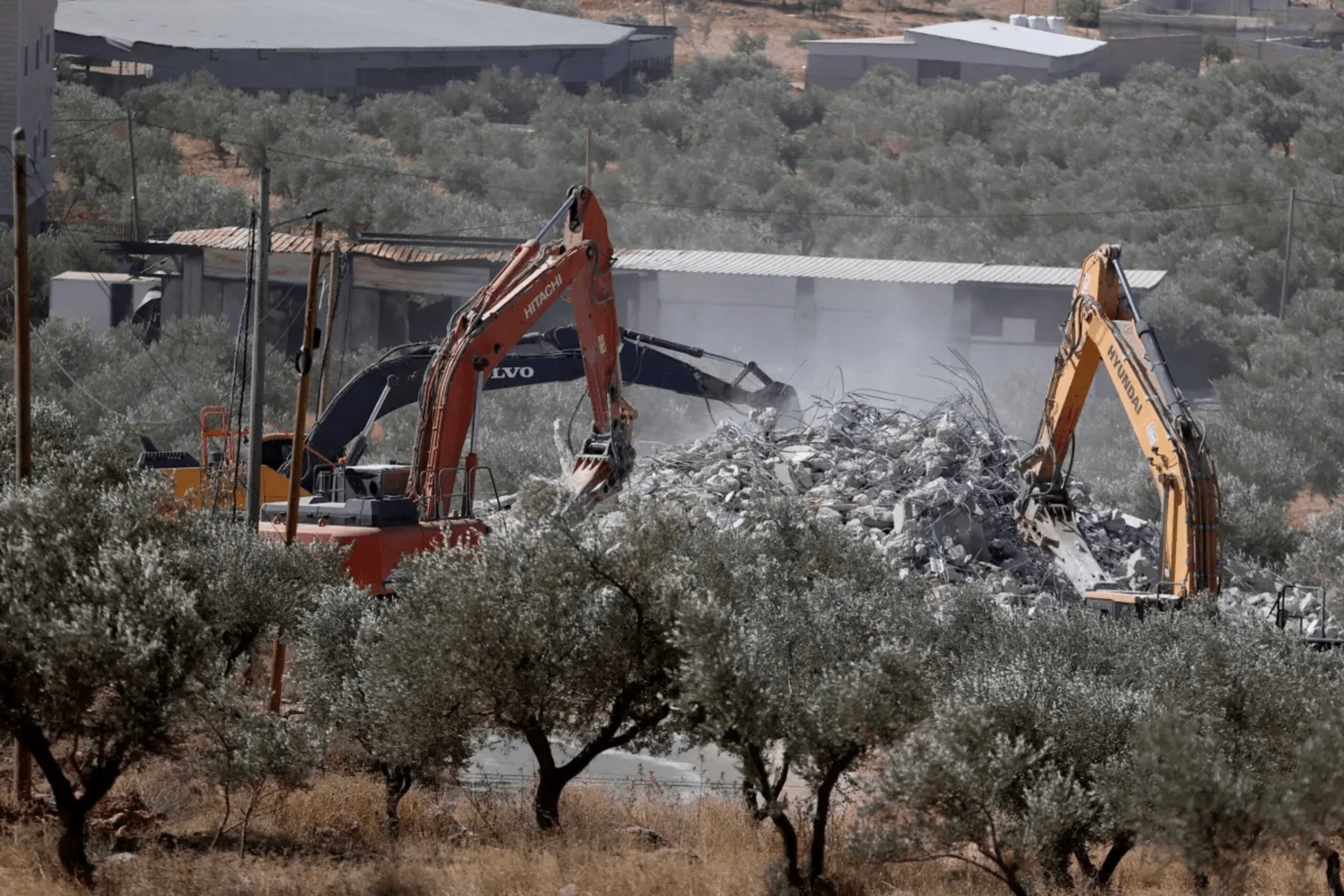 Máquinas pesadas das forças israelenses demolem a casa de uma família palestina supostamente por não ser autorizada em Nablus, Cisjordânia, em 30 de julho de 2024 [Issam Rimawi/ Agência Anadolu]