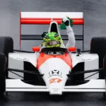 Hamilton homenageia Senna com McLaren MP4/5B em Interlagos, levanta bandeira do Brasil e emociona público sob forte chuva.