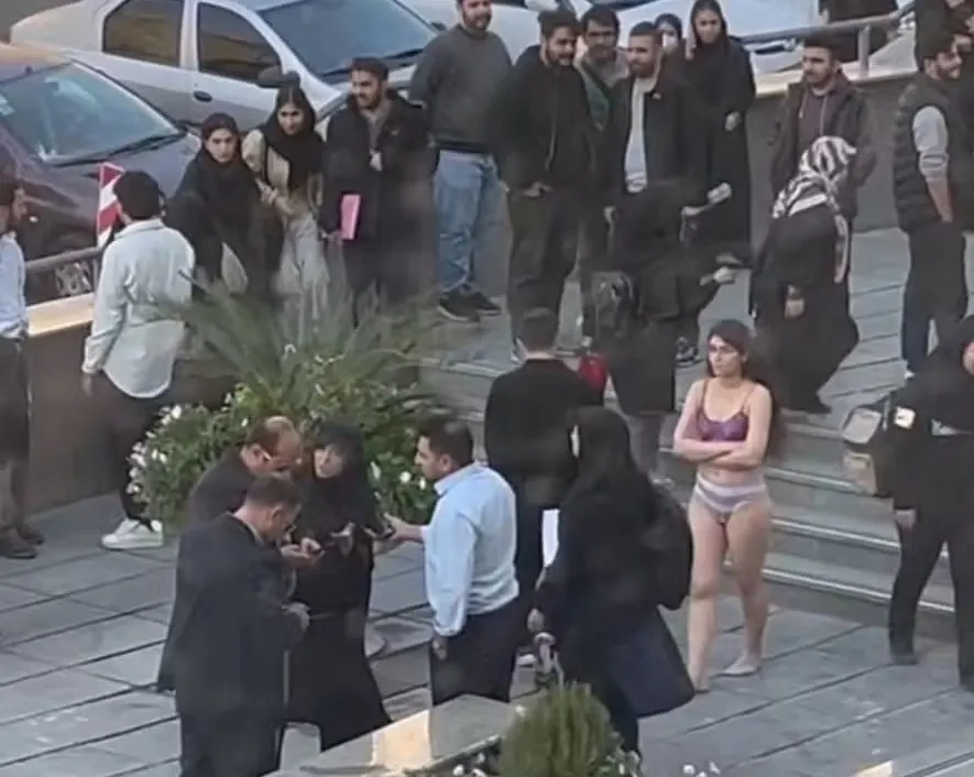 Jovem iraniana detida em protesto contra código de vestimenta no Irã.