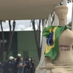 Débora Rodrigues dos Santos, acusada de pichação na estátua "A Justiça", segue presa após pedido de desculpas e manutenção da prisão preventiva.