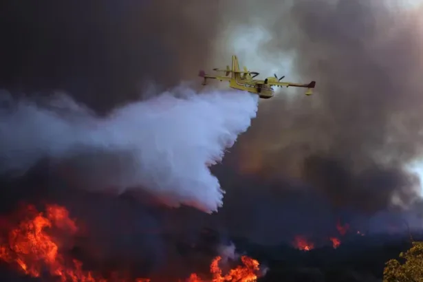 Avião despeja água em um dos incêndios na área de Los Angeles em janeiro de 2025. A água salgada corrói os equipamentos de combate a incêndios e pode prejudicar os ecossistemas. Brian van der Brug / Los Angeles Times via Getty Images